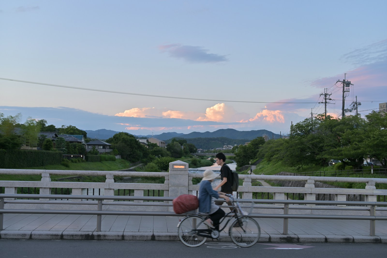 A man riding a bike down a street next to a bridge